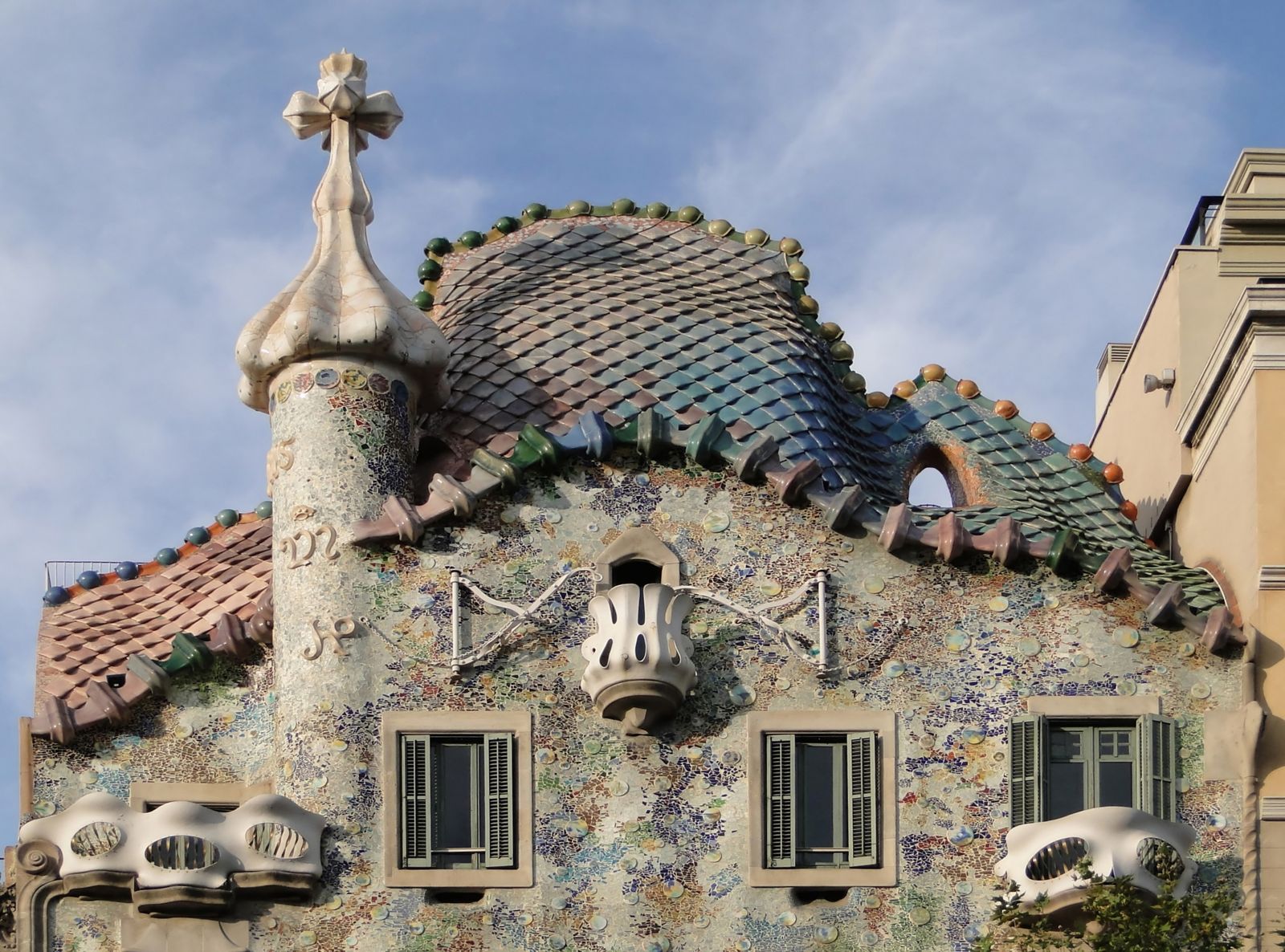 Cobertura da Casa Batlló com telhas de cerâmica em escamas e torre com cruz