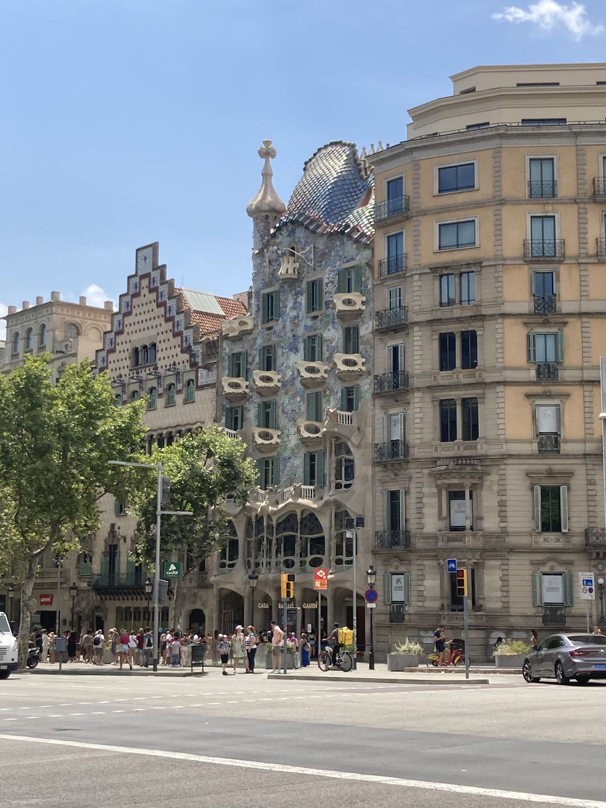 Fachada da Casa Batlló vista da calçada, com colunas de pedra e vidro colorido