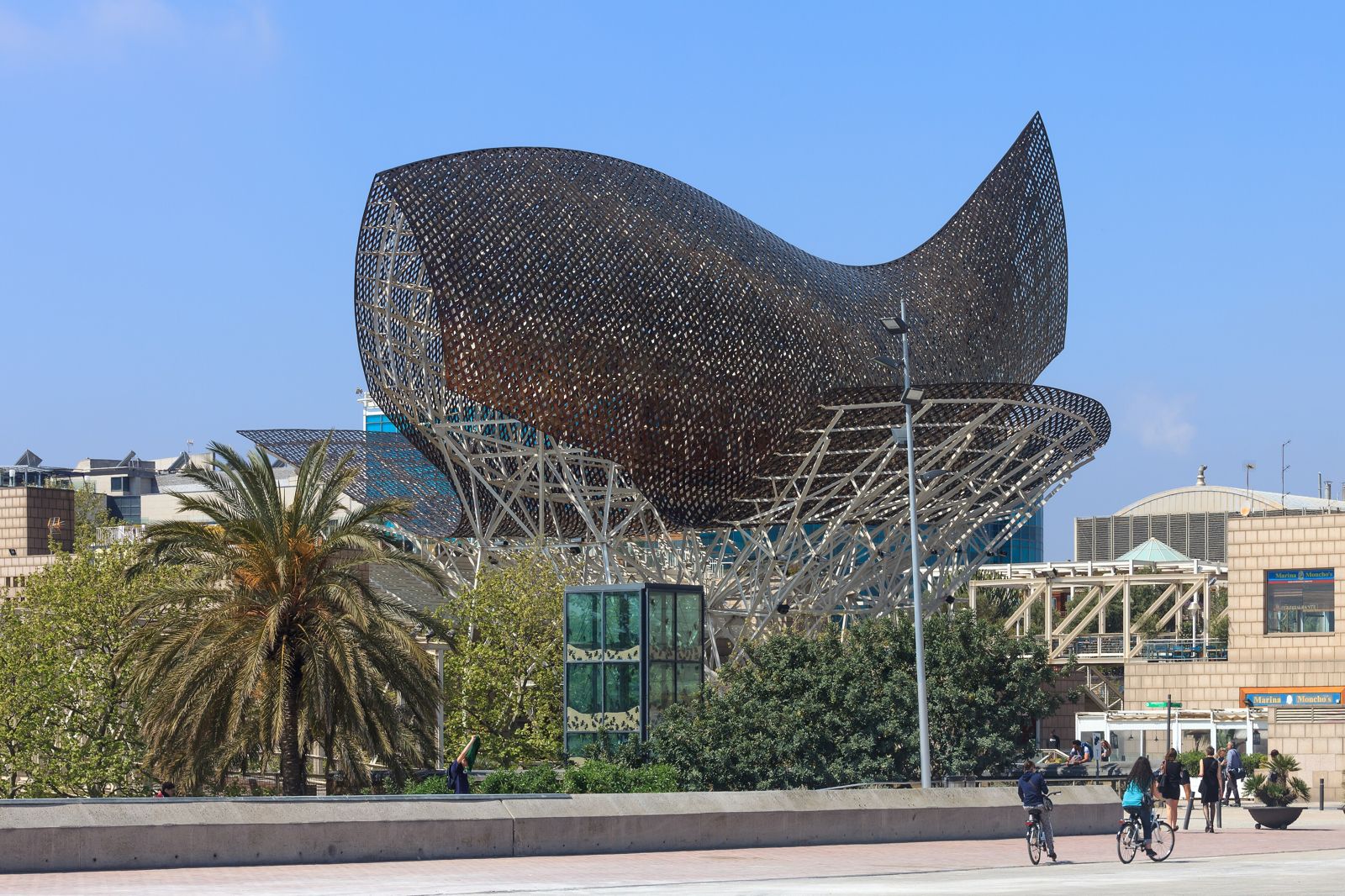 Escultura em forma de peixe de Frank Gehry, em tiras de metal dourado, junto à orla