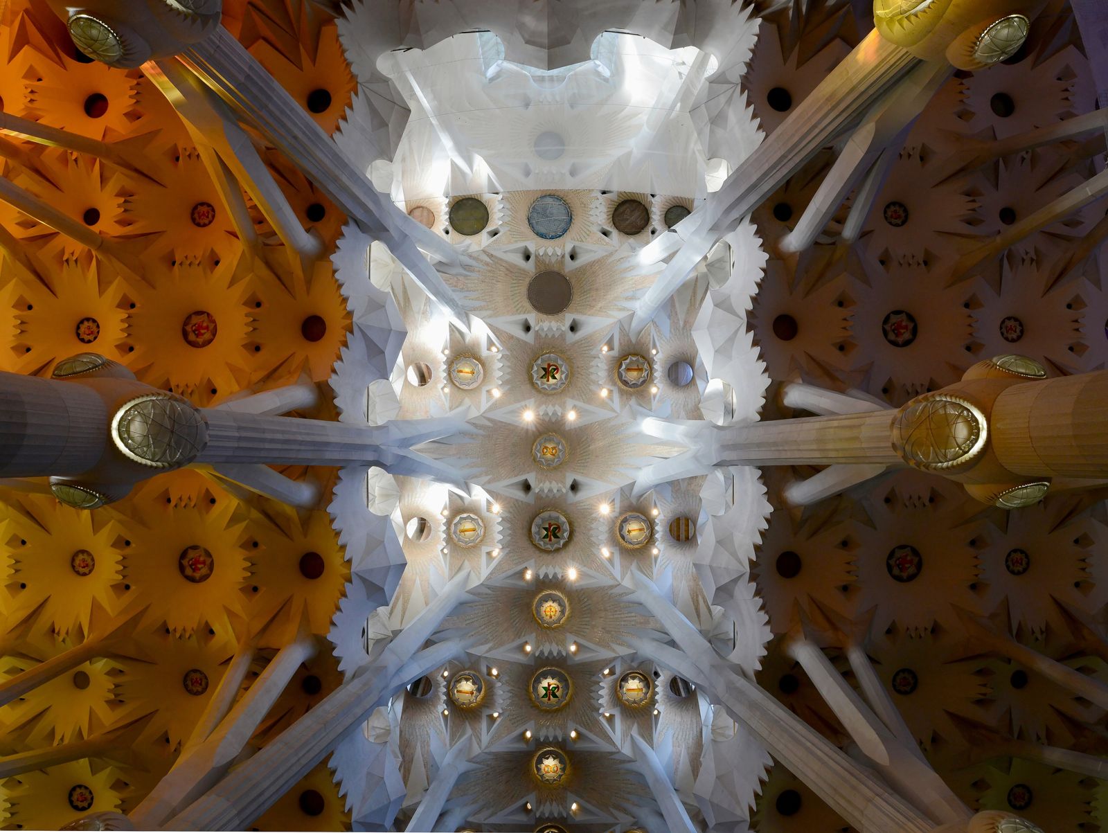 Vista para o alto da abóbada da Sagrada Família, com medalhões e aberturas de luz