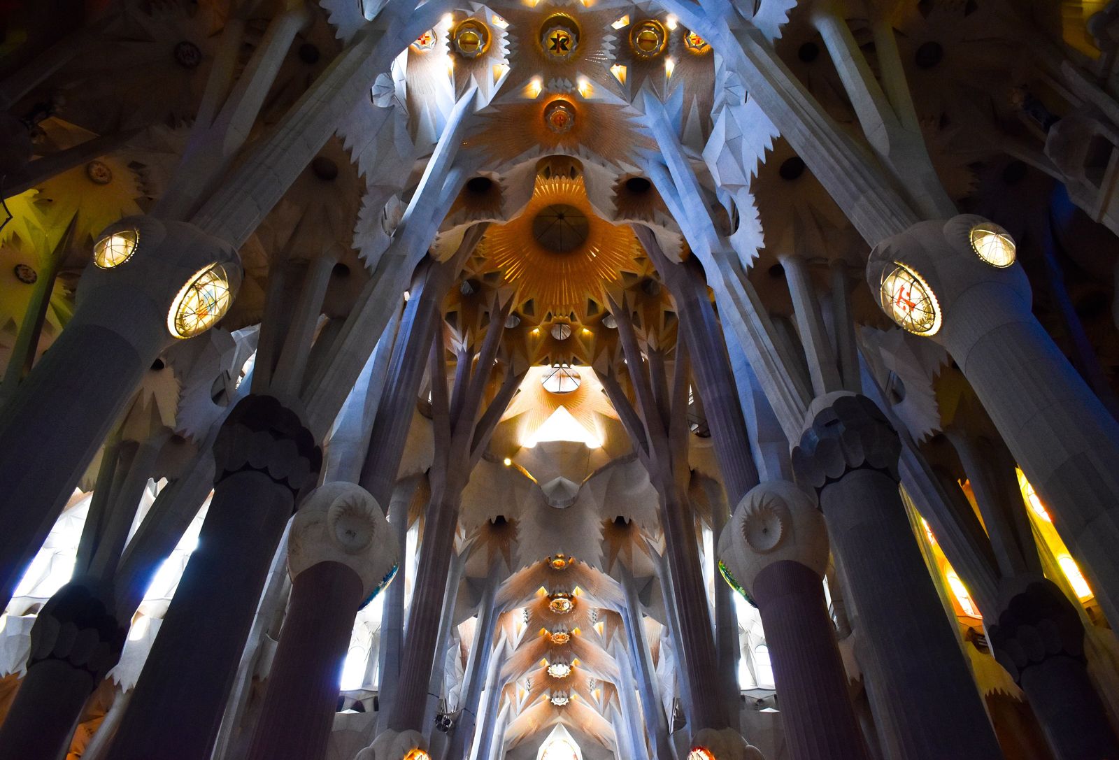 Nave da Sagrada Família, com colunas que se ramificam como troncos de árvore e luz colorida dos vitrais
